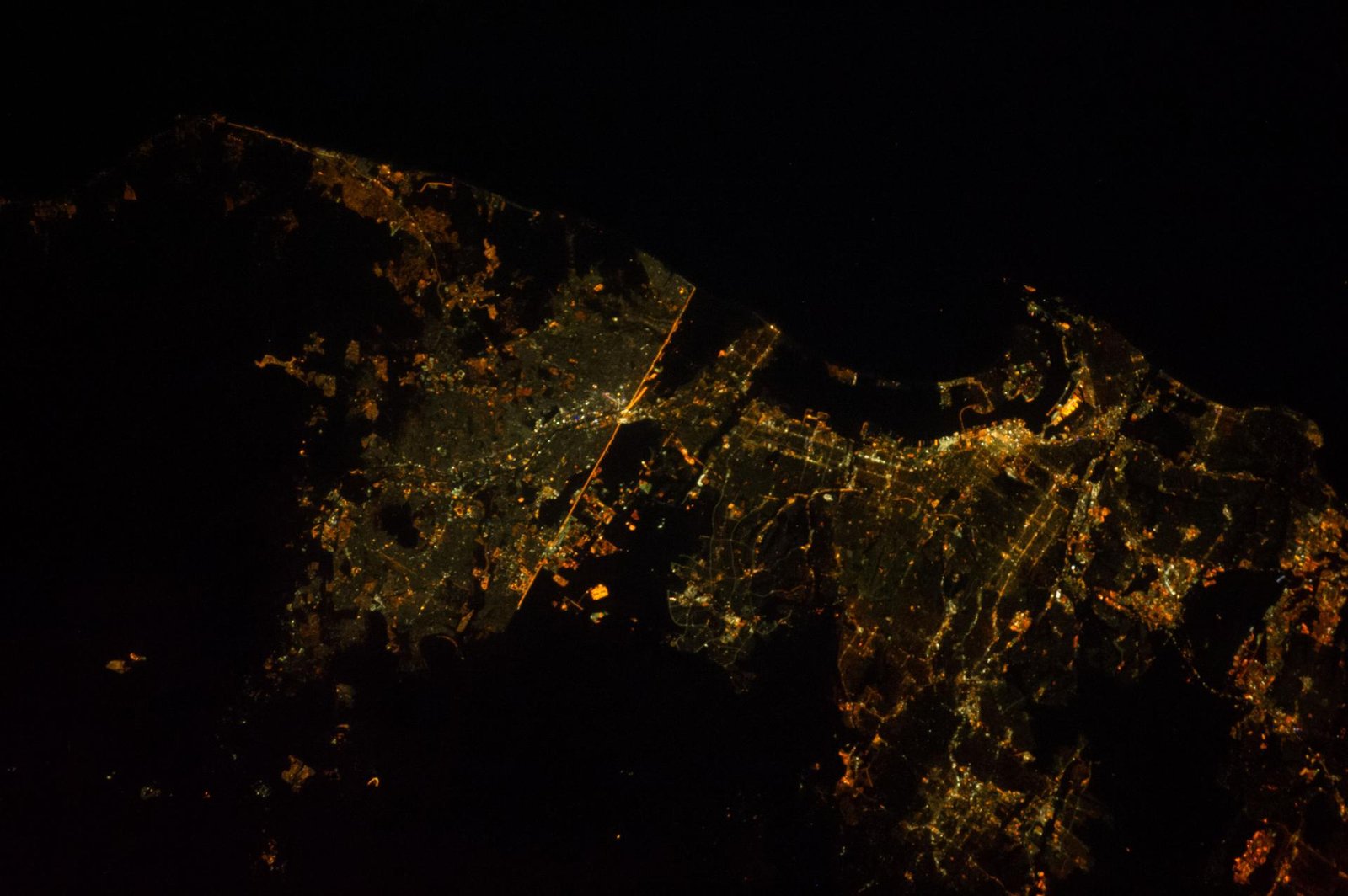 Earth at night seen from orbit, city lights glowing